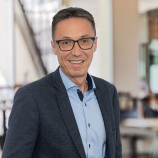 Mann mit Brille in modernem Büro.