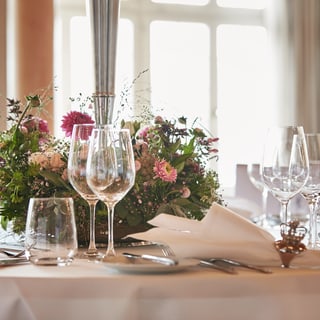 Eleganter Tisch mit Blumen und Gläsern.",