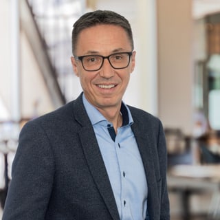 Mann mit Brille in einem modernen Büro.