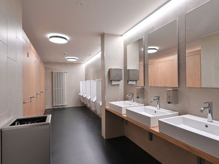 Moderne öffentliche Herrentoilette mit Waschbecken und Urinalen.