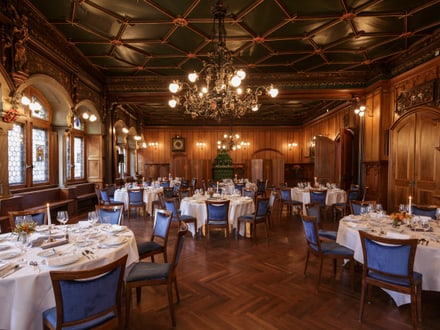 Eleganter Speisesaal mit gedeckten Tischen und Kronleuchtern.