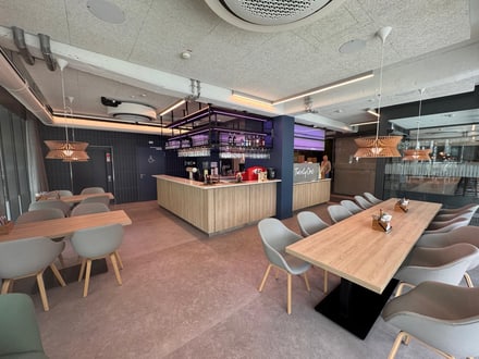 Moderne Bar mit Sitzbereichen und stilvoller Beleuchtung.