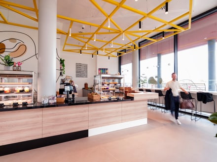 Innenansicht eines modernen Cafés mit Theke und Mensch.