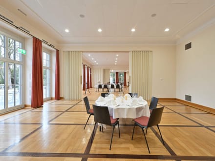 Eleganter Bankettsaal mit rundem Tisch, gedeckt für ein Essen.