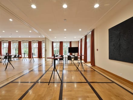 Moderner Konferenzraum mit Stehtischen und Fenstern.