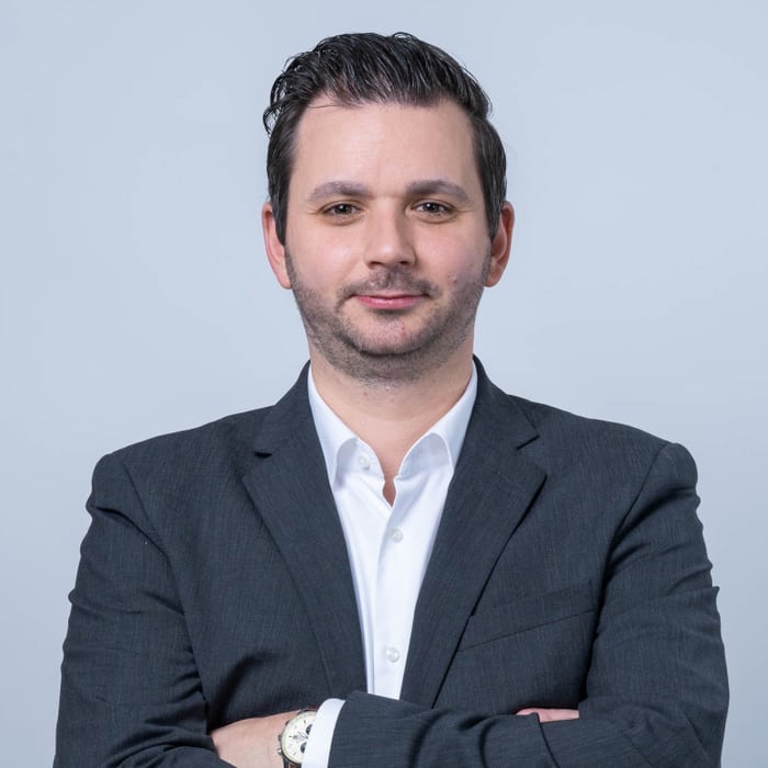 Mann im Anzug mit verschränkten Armen.