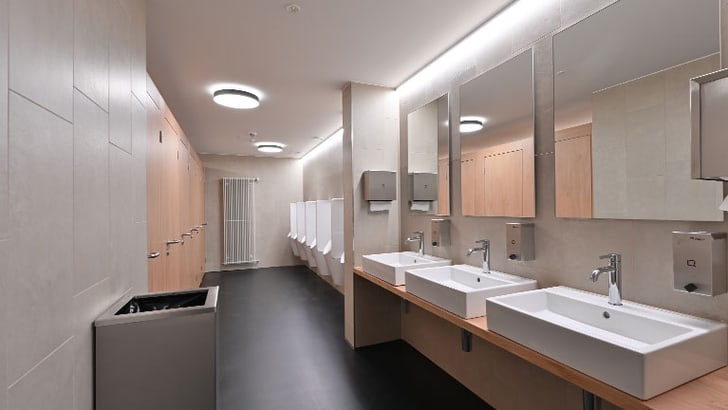 Moderne öffentliche Herrentoilette mit Waschbecken und Urinalen.