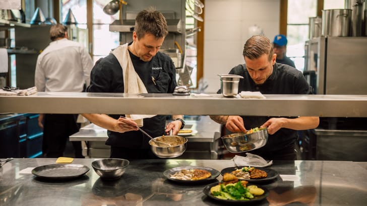 Köche bereiten in der Restaurantküche Gerichte zu.