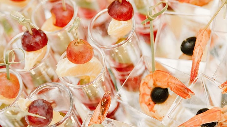 Vorspeisen in Gläsern mit Trauben, Garnelen und Oliven.