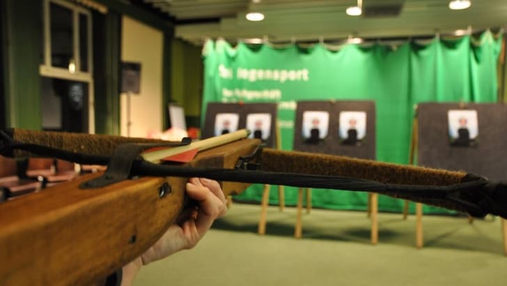 Armbrust in Innenraum auf Zielscheiben gerichtet.