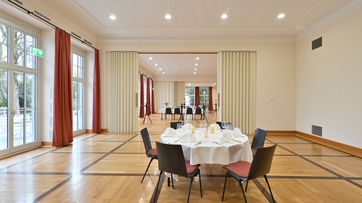 Eleganter Bankettsaal mit rundem Tisch, gedeckt für ein Essen.