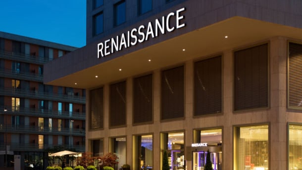 Aussenansicht des Renaissance-Hotels bei Nacht, beleuchtet mit Schildern.