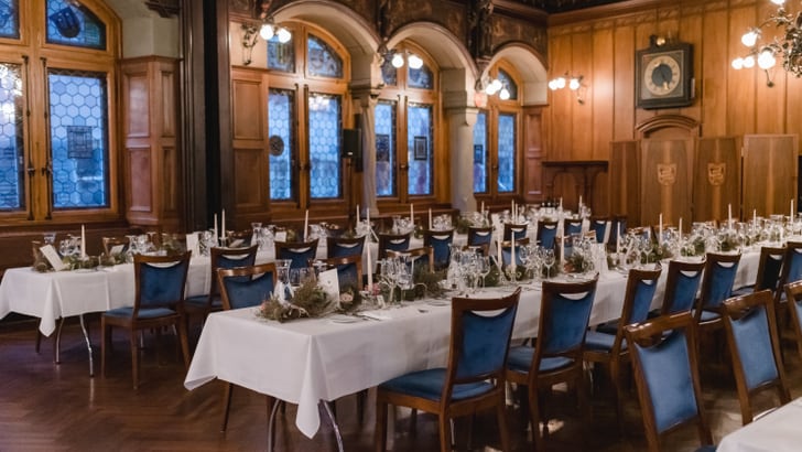 Elegantes Restaurant mit gedeckten Tischen und blauen Stühlen.