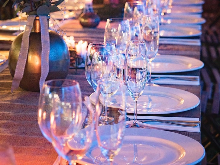 Eleganter Tisch mit Gläsern und Tellern dekoriert für Abendessen.