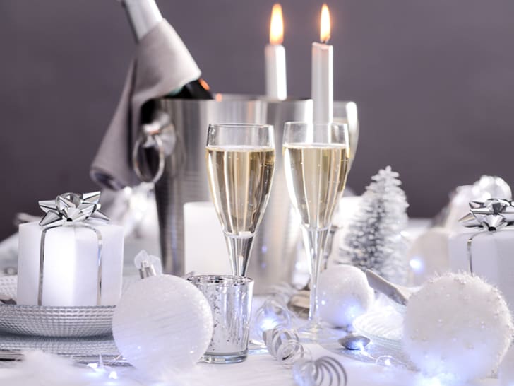 Festliche Tischdekoration mit Geschenken und Kerzen.