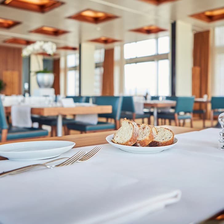 Eleganter Restauranttisch mit Brotteller und Gewürzen.