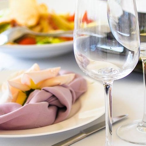 Elegant gedeckter Tisch mit Gläsern und Tellern.