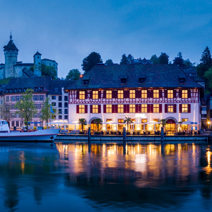 Abendstimmung mit beleuchteter Altstadt am Flussufer.