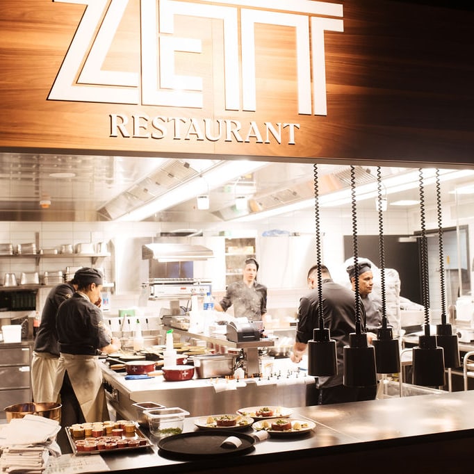Küchenchef und Team in einem Restaurant mit offenem Küchenkonzept.