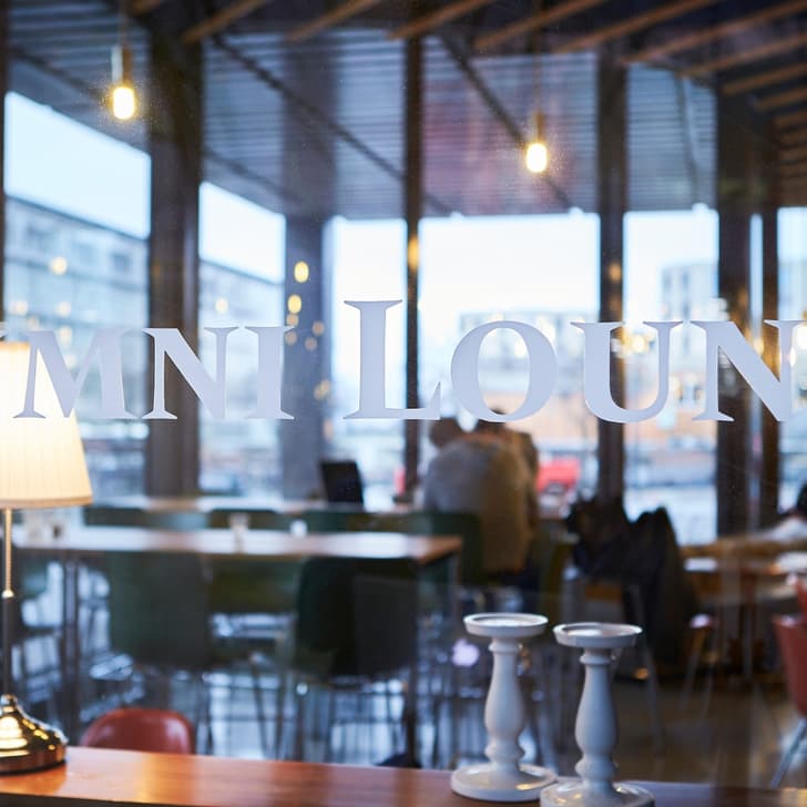 Alumni Lounge mit Tischlampen und Kerzenhaltern im Fenster sichtbar.