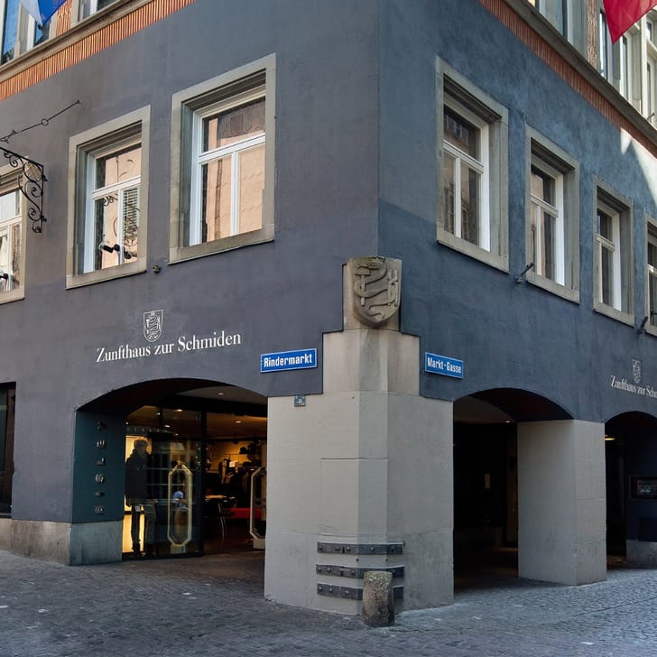 Historisches Gebäude mit Ladenschildern an einer Strassenecke.