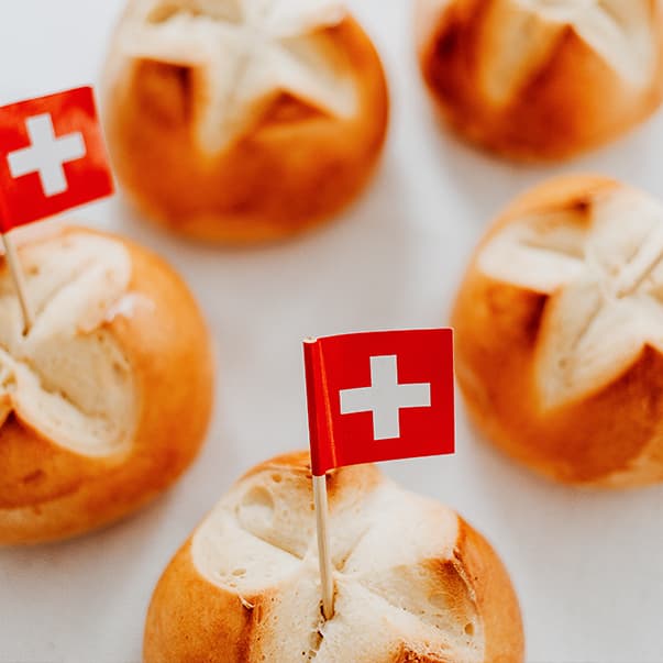 Fünf Brötchen mit Schweizer Fähnchen.