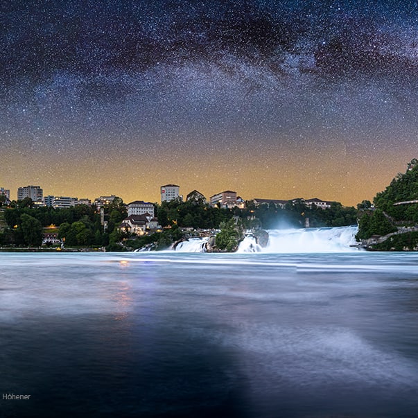 Nachthimmel über Rheinfall mit Gebäuden am Ufer.