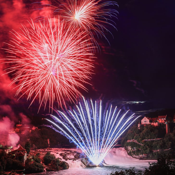 Feuerwerk über dem Rheinfall bei Nacht.
