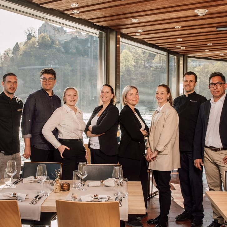 Restaurantteam im Speisesaal mit Blick auf Wasserfall.
