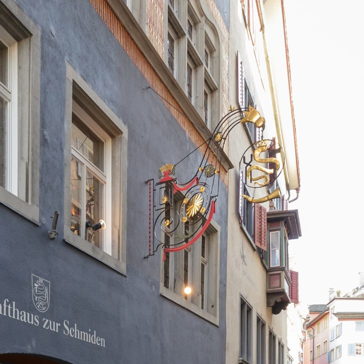Zunfthaus zur Schmiden in einer engen Strasse mit historischem Schild.
