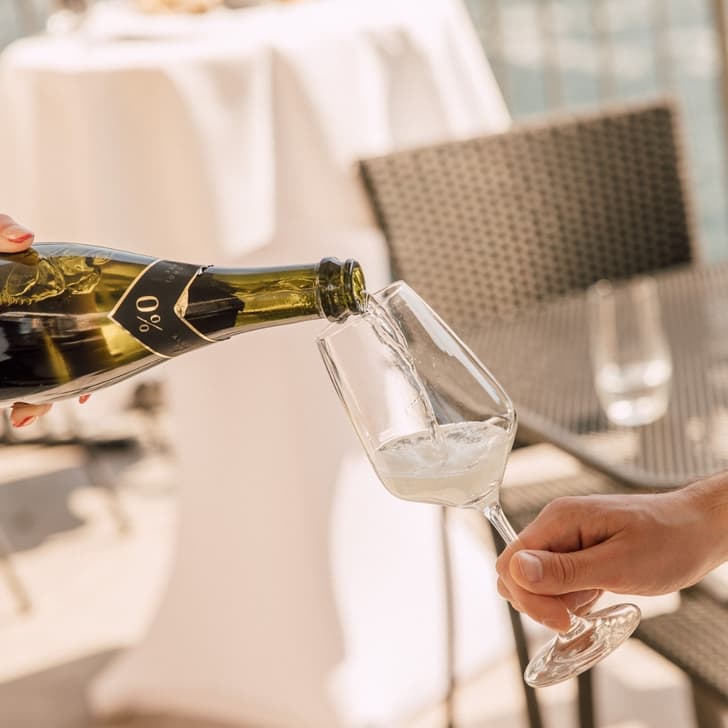 Schaumwein in Glas auf Terrasse eingegossen.
