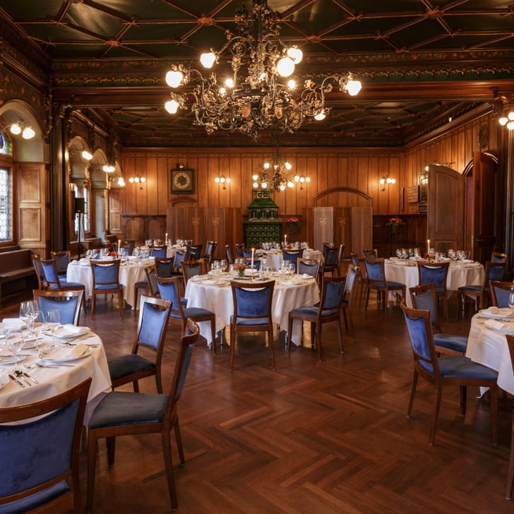 Elegantes Restaurant mit gedeckten Tischen und Kronleuchtern.
