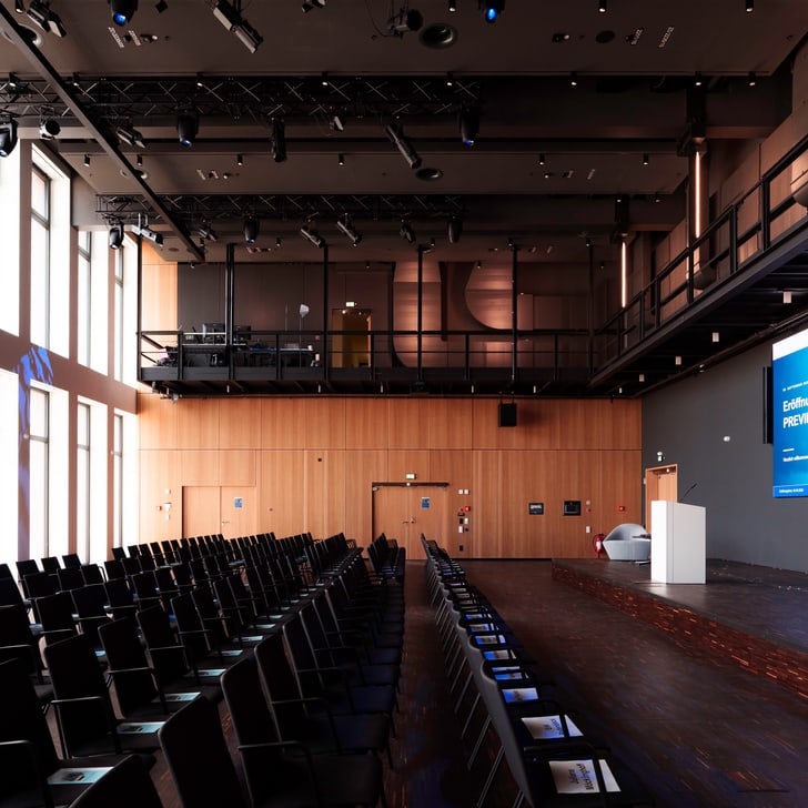 Leerer Konferenzraum mit Projektor und Stühlen.