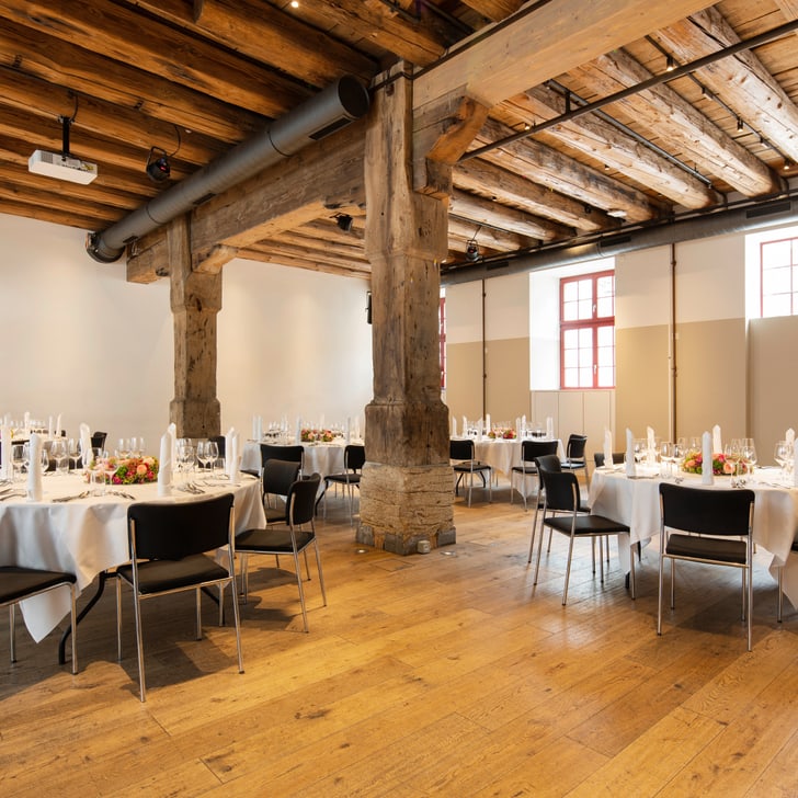 Elegant gedeckter Veranstaltungsraum mit Holzdecke und -boden.