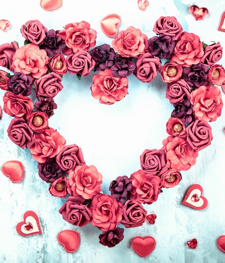 Herz aus Rosenblüten mit kleinen Herzen dekoriert.