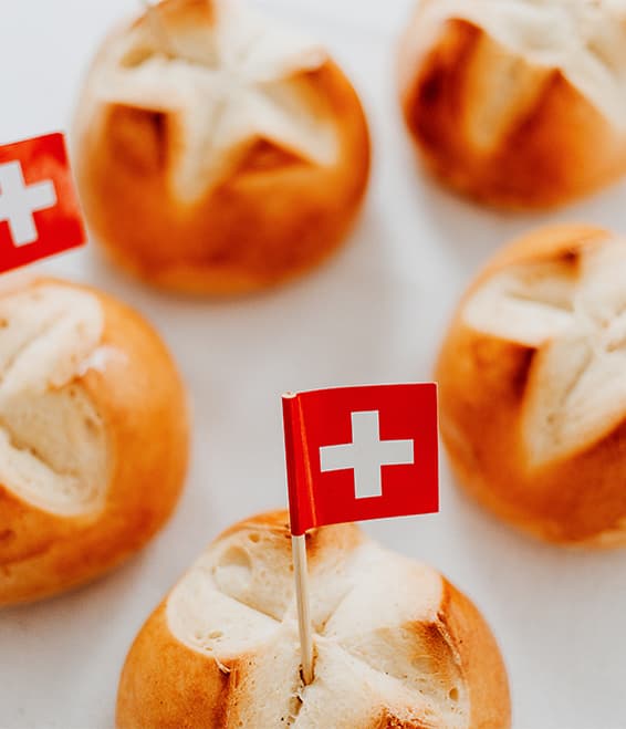 Schweizer Brötchen mit Fahnen auf Tisch.