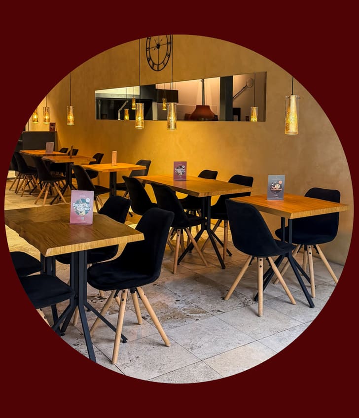 Leeres Café mit schwarzen Stühlen und Holztischen.