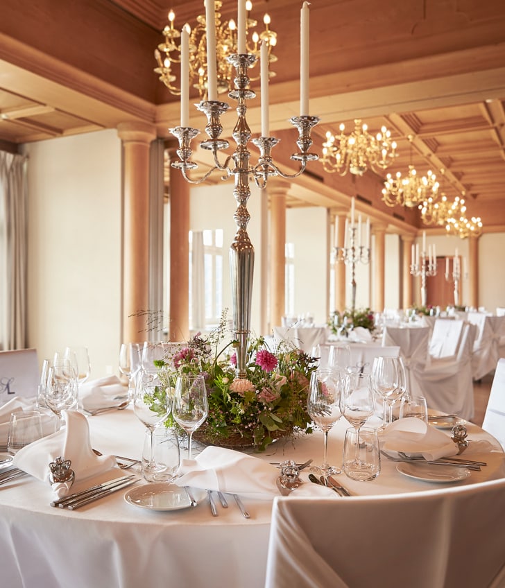 Eleganter Bankettsaal mit gedeckten Tischen und Kronleuchtern.