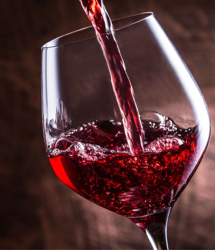 Rotwein wird in ein Glas gegossen.