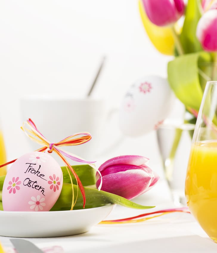 Frühstückstisch mit Osterei und Tulpen.",