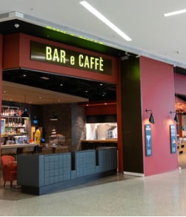 Innenansicht eines Einkaufszentrums mit Cafés und Restaurants.