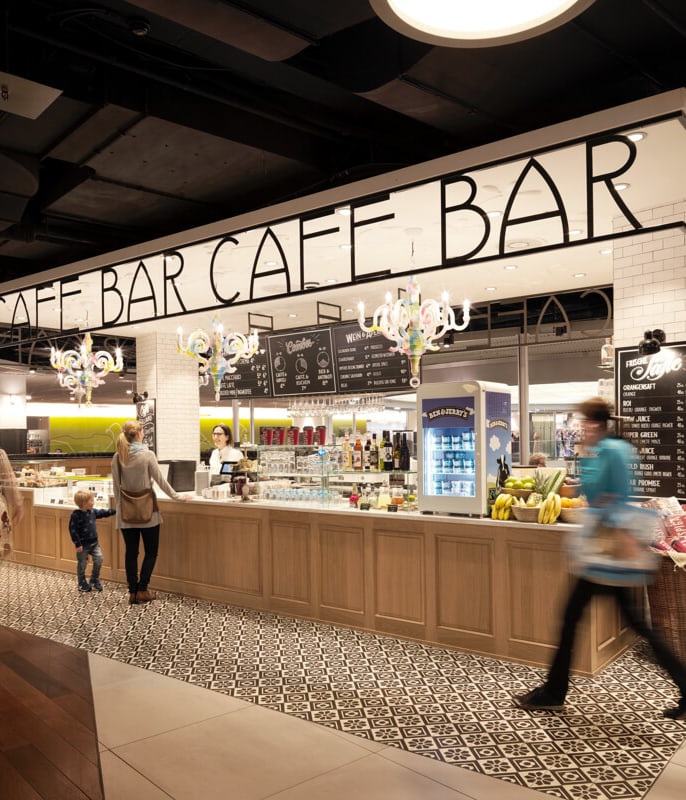 Cafébar in einem Einkaufszentrum mit Menschen, die vorbeigehen.
