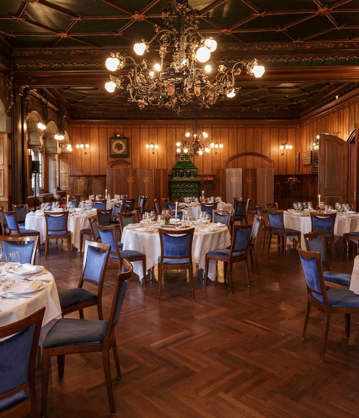 Elegantes Restaurant mit gedeckten Tischen und Kronleuchtern.