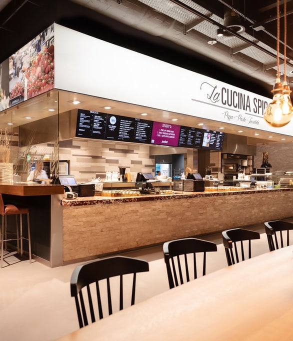 Moderne Cafeteria mit Sitzbereichen und Theken.