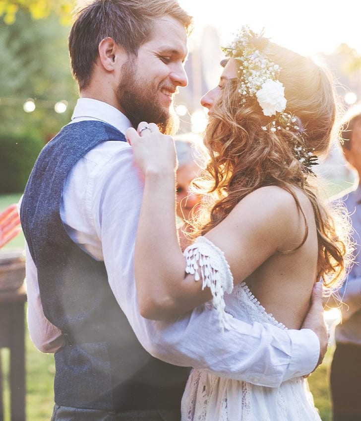 Paar tanzt bei einer Hochzeit im Freien bei Sonnenuntergang.