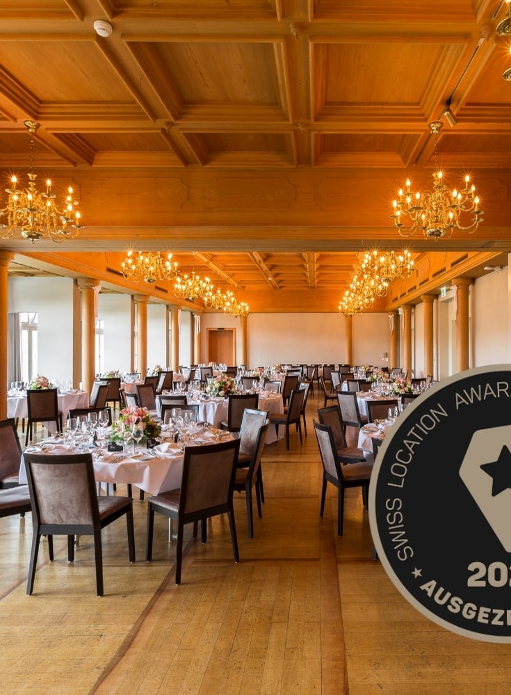 Eleganter Speisesaal mit Tischen und Stühlen, ausgezeichnetes Abzeichen sichtbar.