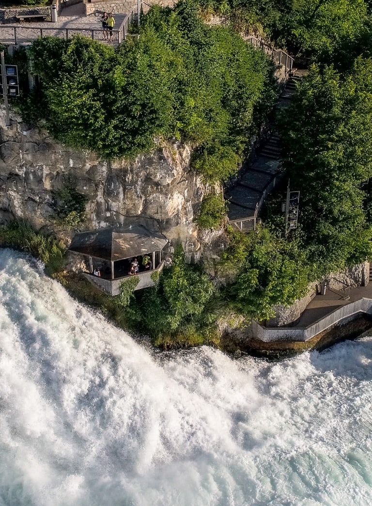 Luftaufnahme des Rheinfalls mit Plattform und Treppen am Felsenrand.