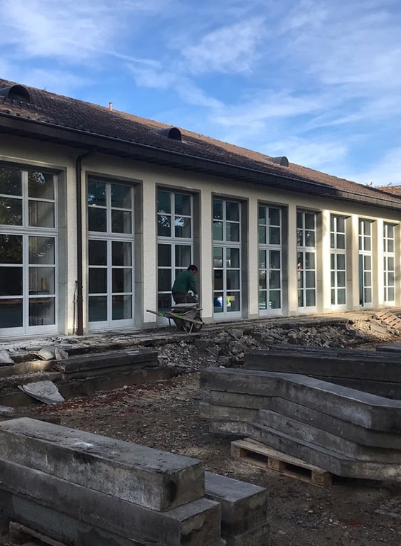 Gebäude mit grossen Fenstern und Renovierungsarbeiten davor.