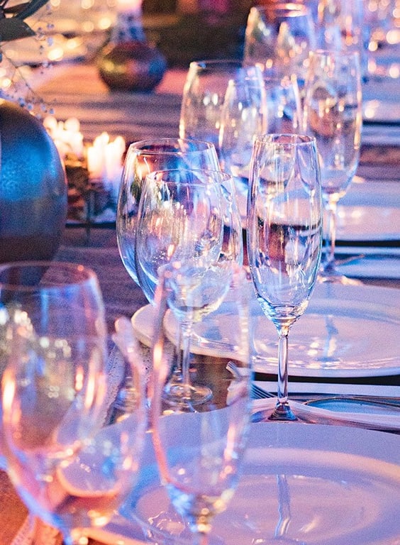 Eleganter Tisch mit Gläsern und Tellern dekoriert für Abendessen.