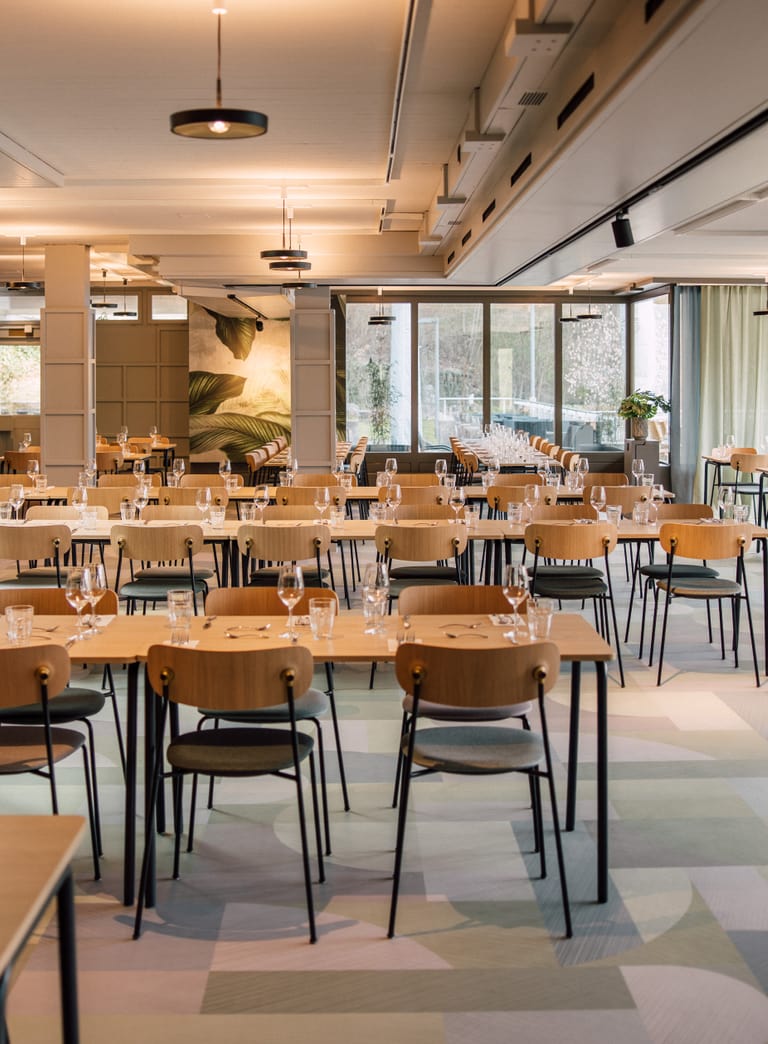 Grosses, modernes Restaurant mit gedeckten Tischen und Stühlen.